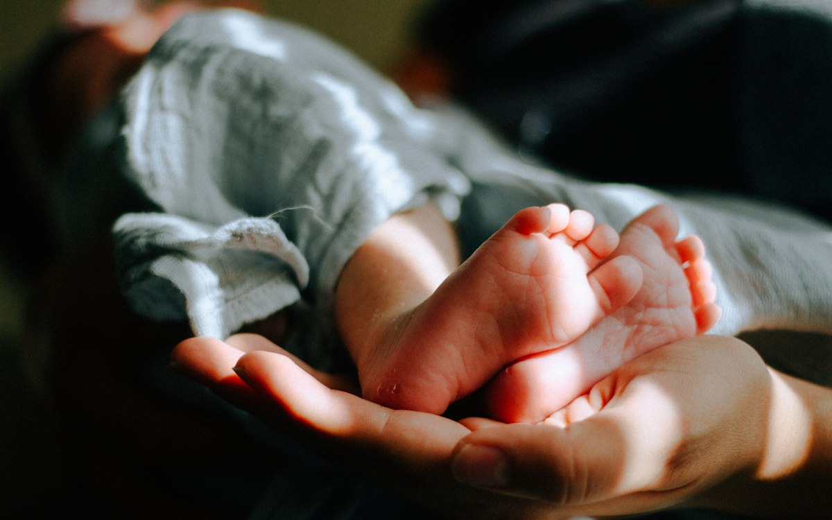 Newborn resting peacefully in a gentle sleep training nursery environment
